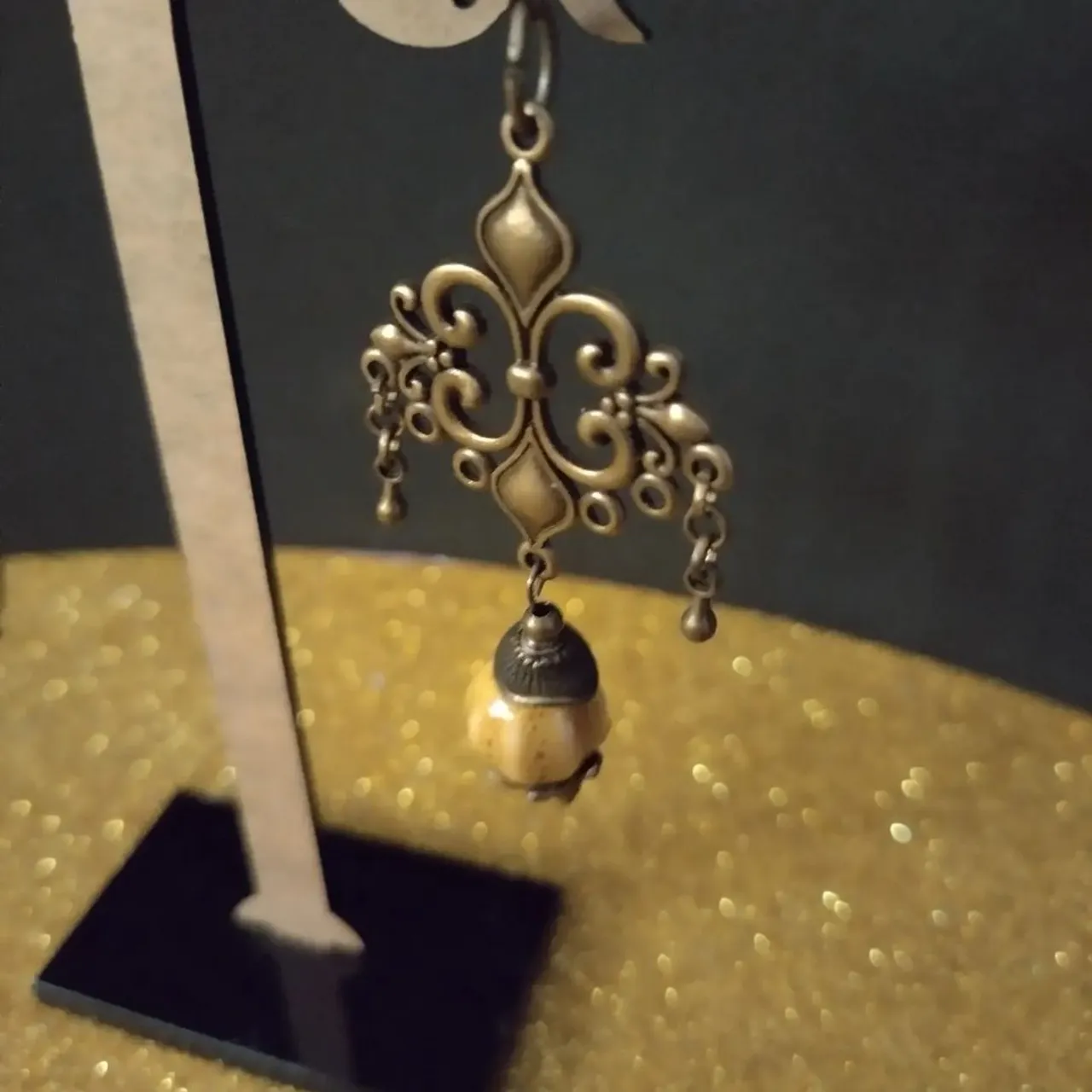 Orecchini in metallo colore ottone anticato con perle in ceramica.
Ancient brass metal earrings with ceramic beads.