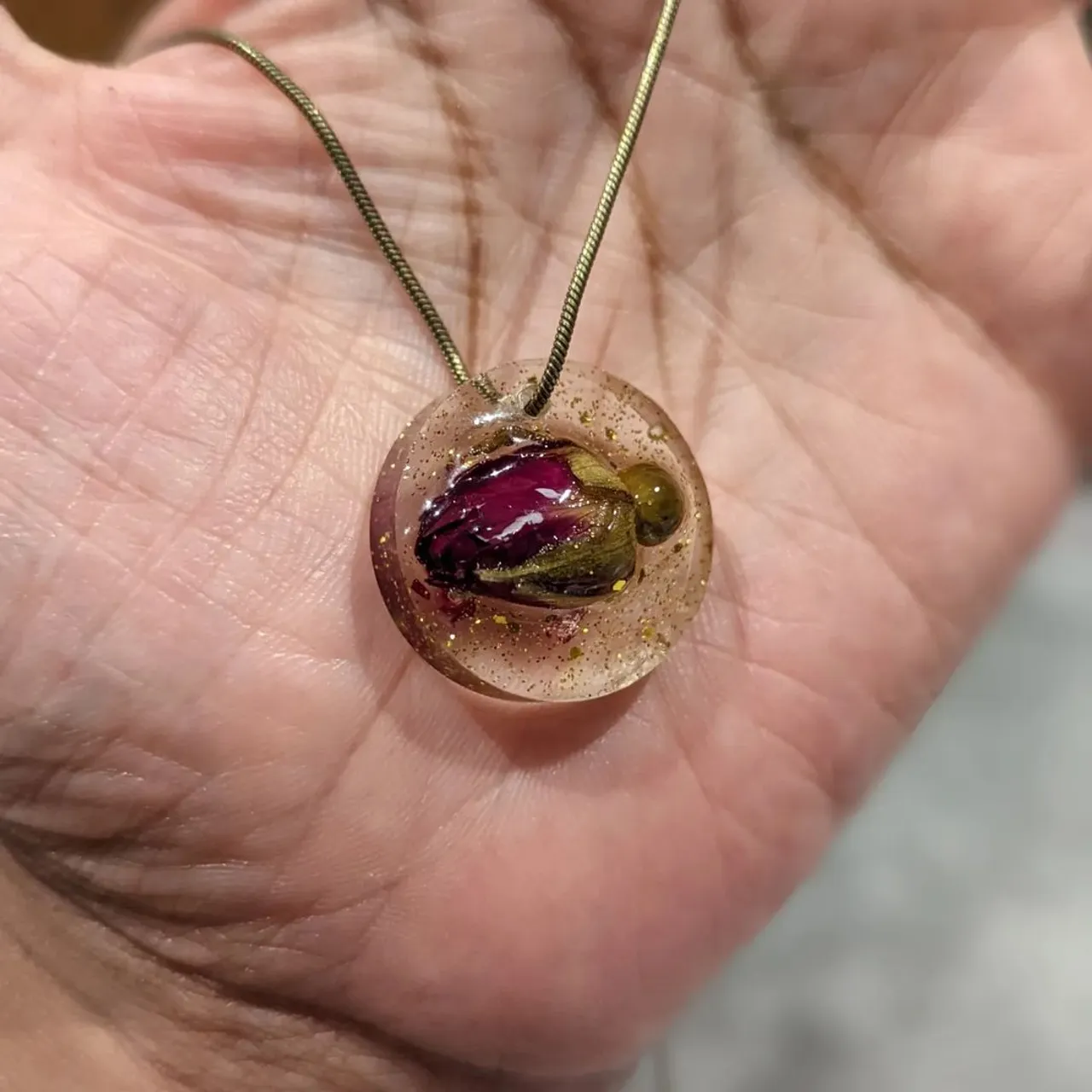 Resin necklace with raised dried rosebud and gold sparkles.🌹
Comes on an antique style snake chain.
Designed and made by Rachael.
#resin #resinjewelry #resinart #handmadejewelry #handmadeuk #handmade