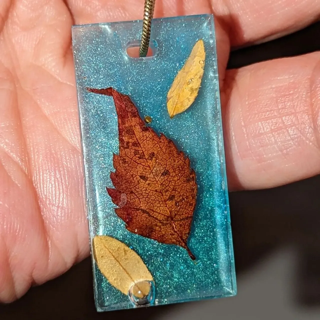 New falling leaves necklace! 🍂

Real autumn leaves preserved in clear resin on a sky blue background.

This necklace comes on an antique style snake chain and will be available in our shop from tomorrow!

#autmncolors #autumnjewellery #giftideas #handmadejewellery #handmadeuk #christmasgift #jewellerymaker #etsyseller #etsyuk