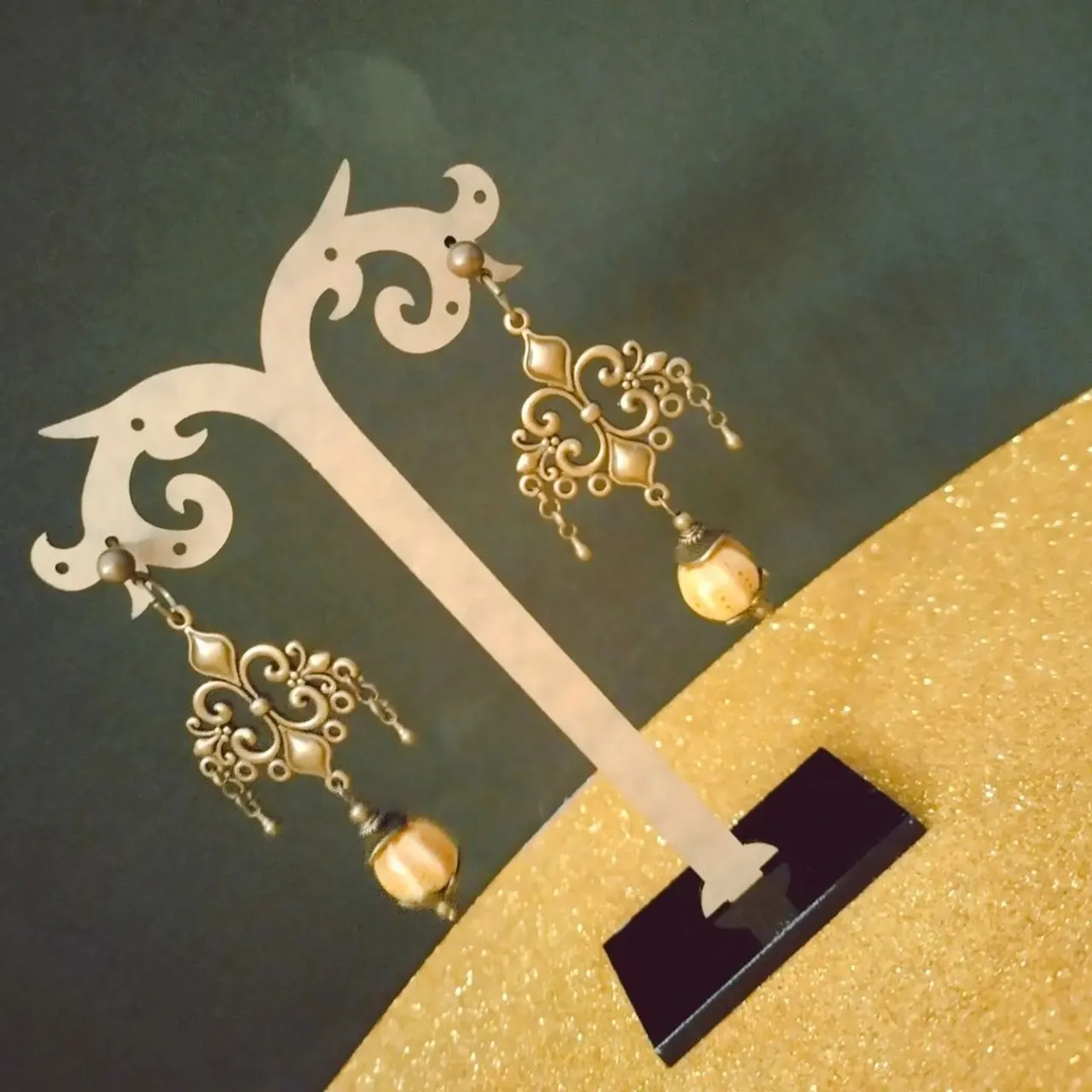 Orecchini in metallo colore ottone anticato con perle in ceramica.
Ancient brass metal earrings with ceramic beads.