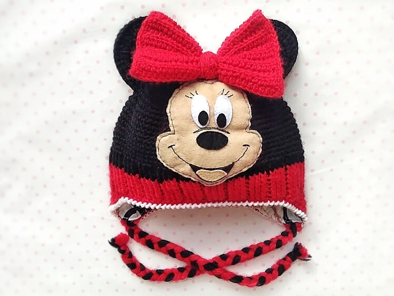 Get ready for some Disney magic with this adorable knitted Minnie Mouse hat! This hat is perfect for both adults and children. It will be an essential item for any fan of the iconic cartoon character. Made with love and attention to detail, this hat features Minnie Mouse's signature ears and is designed to keep you warm and stylish during the cooler months. Whether you're dressing up for Halloween or just want to add some Disney charm to your everyday look, this crochet Minnie Mouse hat is the perfect accessory. Don't miss this cool and cute hat that will make you feel part of the magical world of Disney!