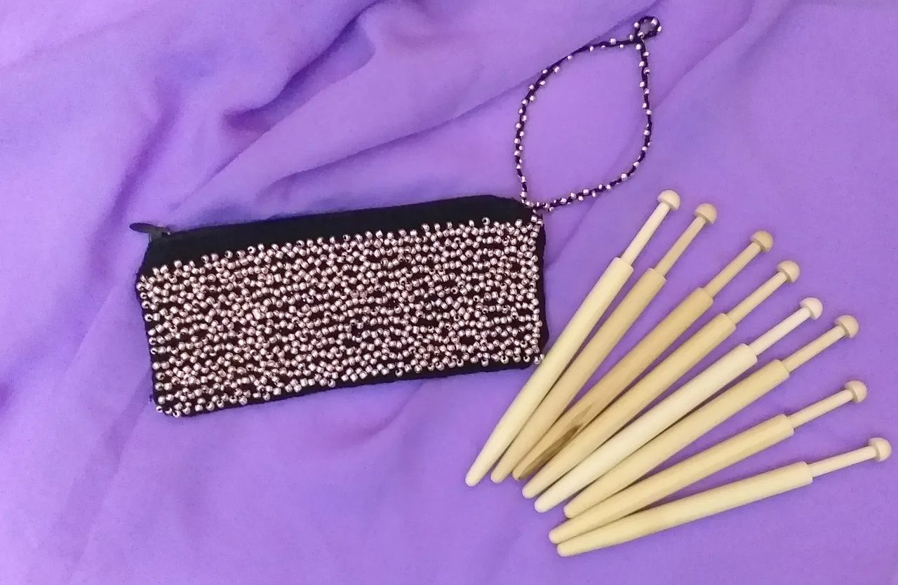 The process of creating a lace bag woven on bobbins. Bobbin lace making.