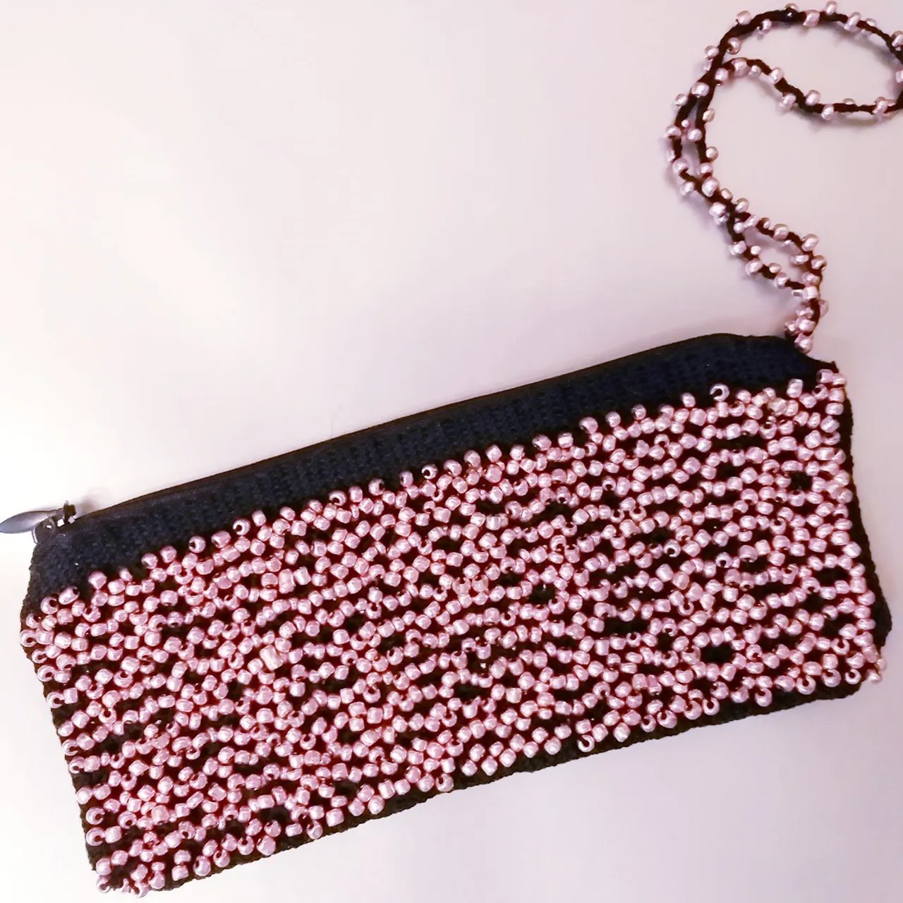 Black lace bag with beads woven on bobbins. Lace making.