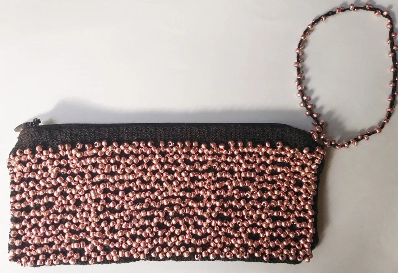 Black lace bag with beads woven on bobbins. Lace making.