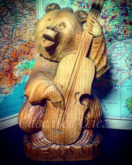 Wooden sculpture, a bear plays the double bass.