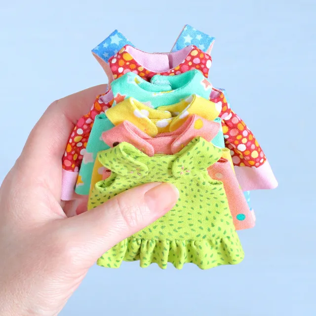 Take a closer look at these tiny doll clothes! Look how neat the necklines and armholes look. All thanks to the lining! This set of clothes is part of the bundle of 5 digital sewing patterns that includes step-by-step photo instructions and full-size pattern pieces to make four 6" mini rag dolls with an 8-piece Summer capsule wardrobe. The sewing pattern is easy to follow and beginner friendly. Buy it now and learn how to sew your own cloth dress up doll with large set of clothes!
