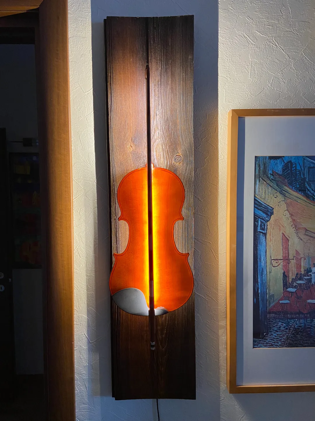 A wall sconce made from an old violin and a bow