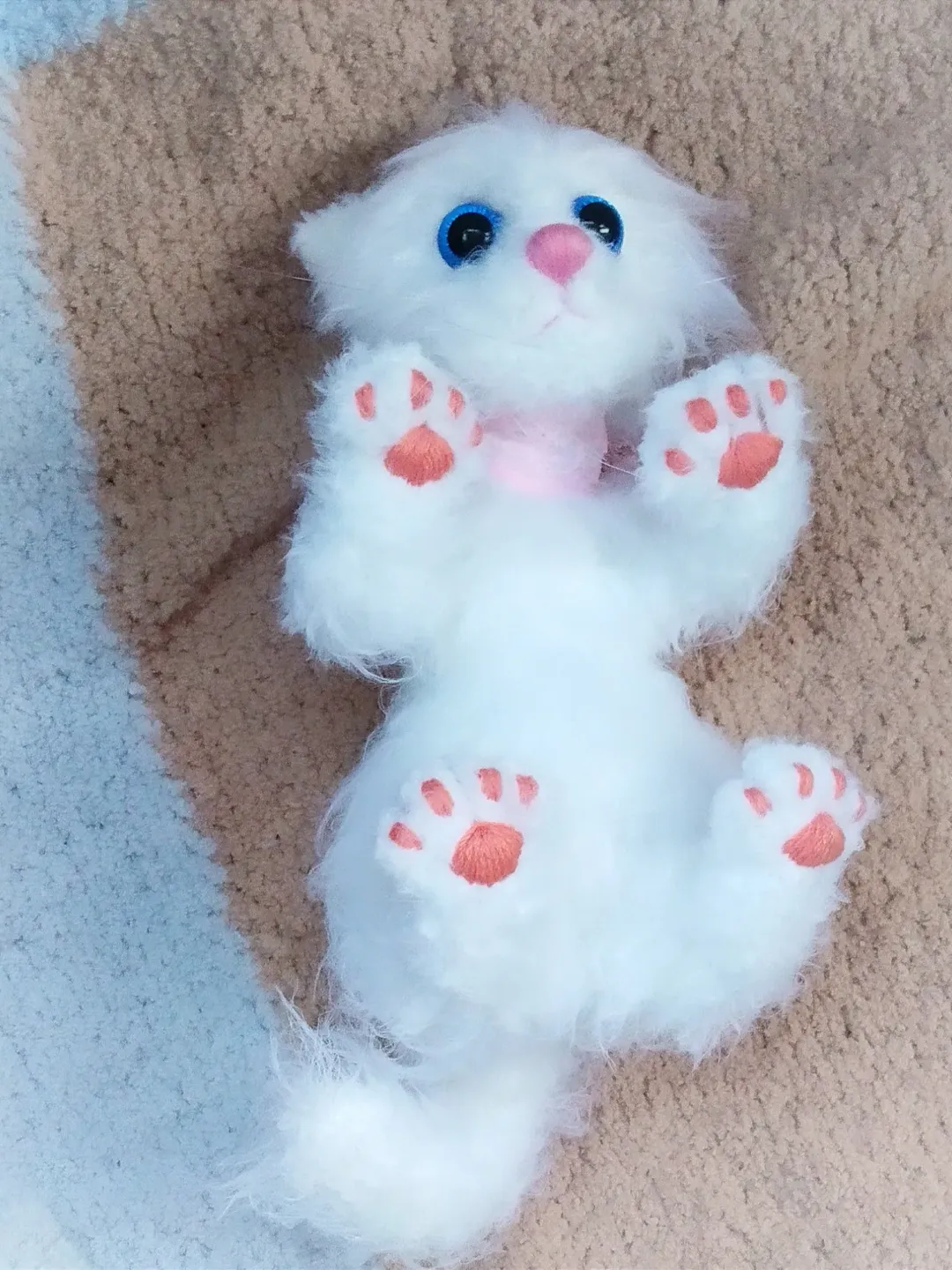 Snow-white kitten as a real toy with movable paws for a teenage girl, fluffy realistic plush cat, realistic stuffed cat