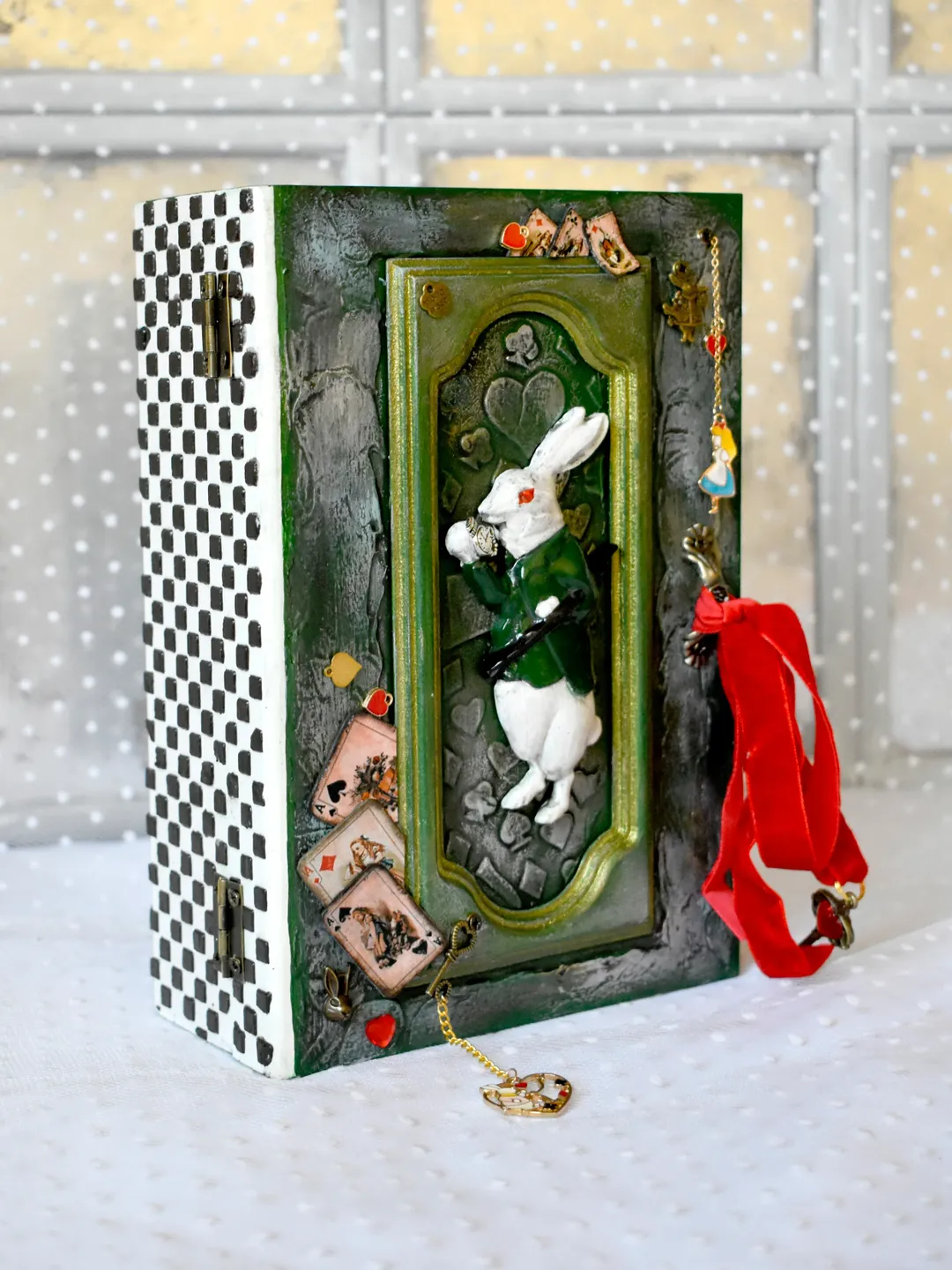 A green box with a white rabbit from Alice a box for cards or jewerly