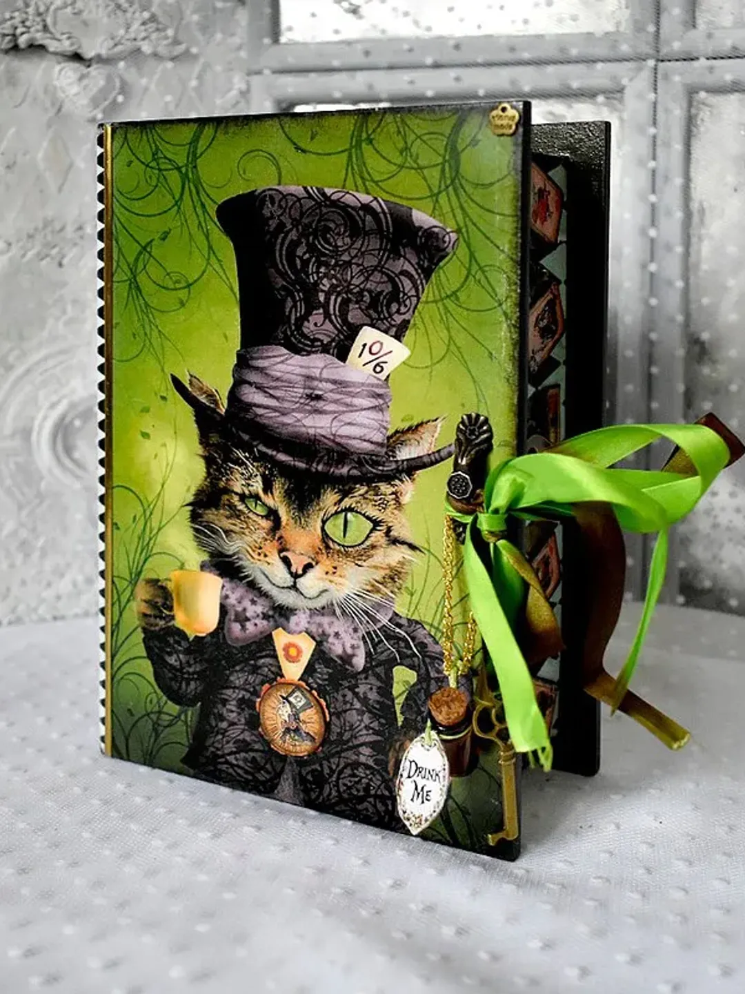 A green box-book with for cards for storage Alice fans