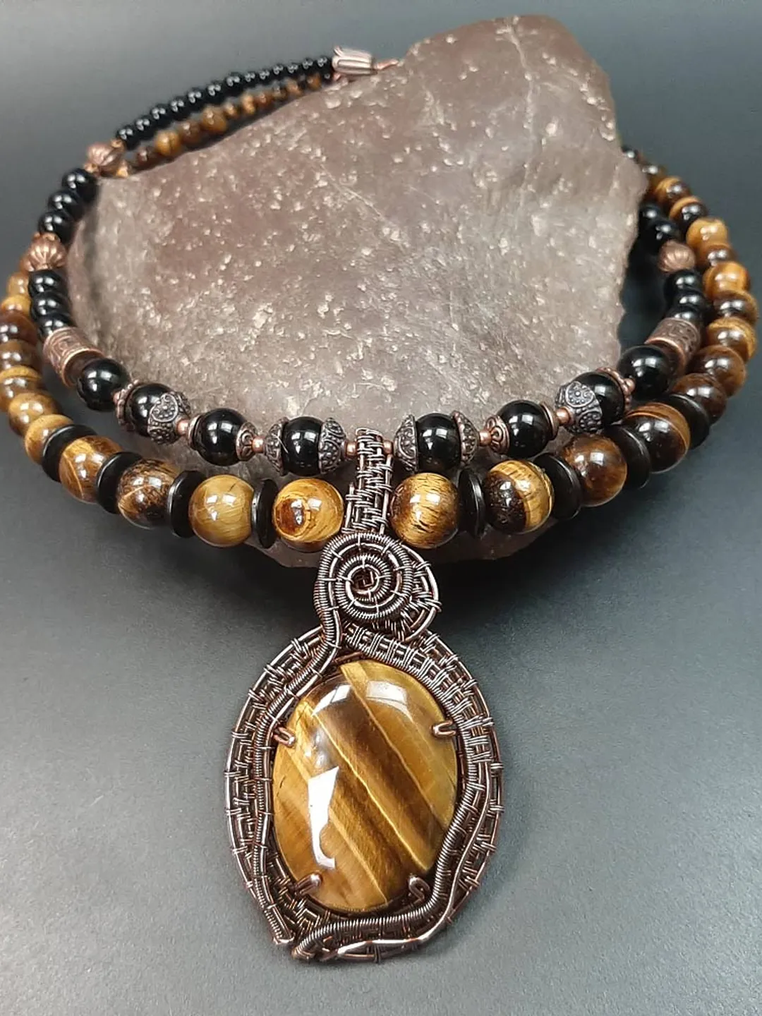Handmade pendant made of Tiger Eye stone and copper wire.