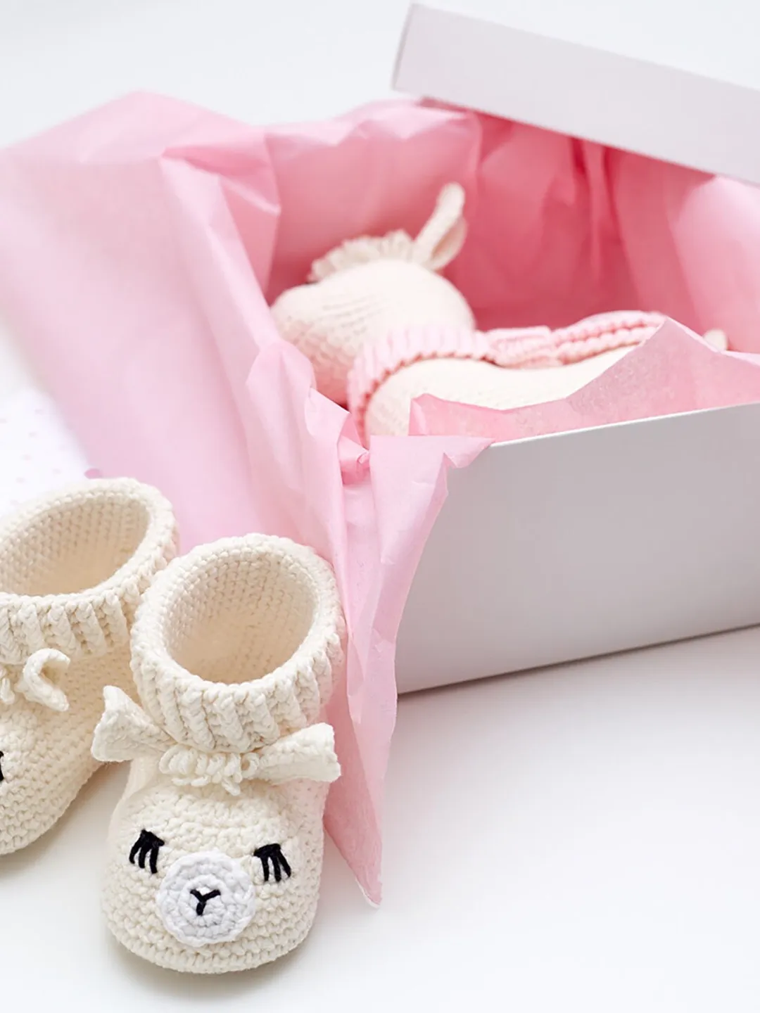 Pregnancy gift basket for newly expecting mom with the best newborn present set of cute crochet llama stuffed alpaca toy and animal booties.