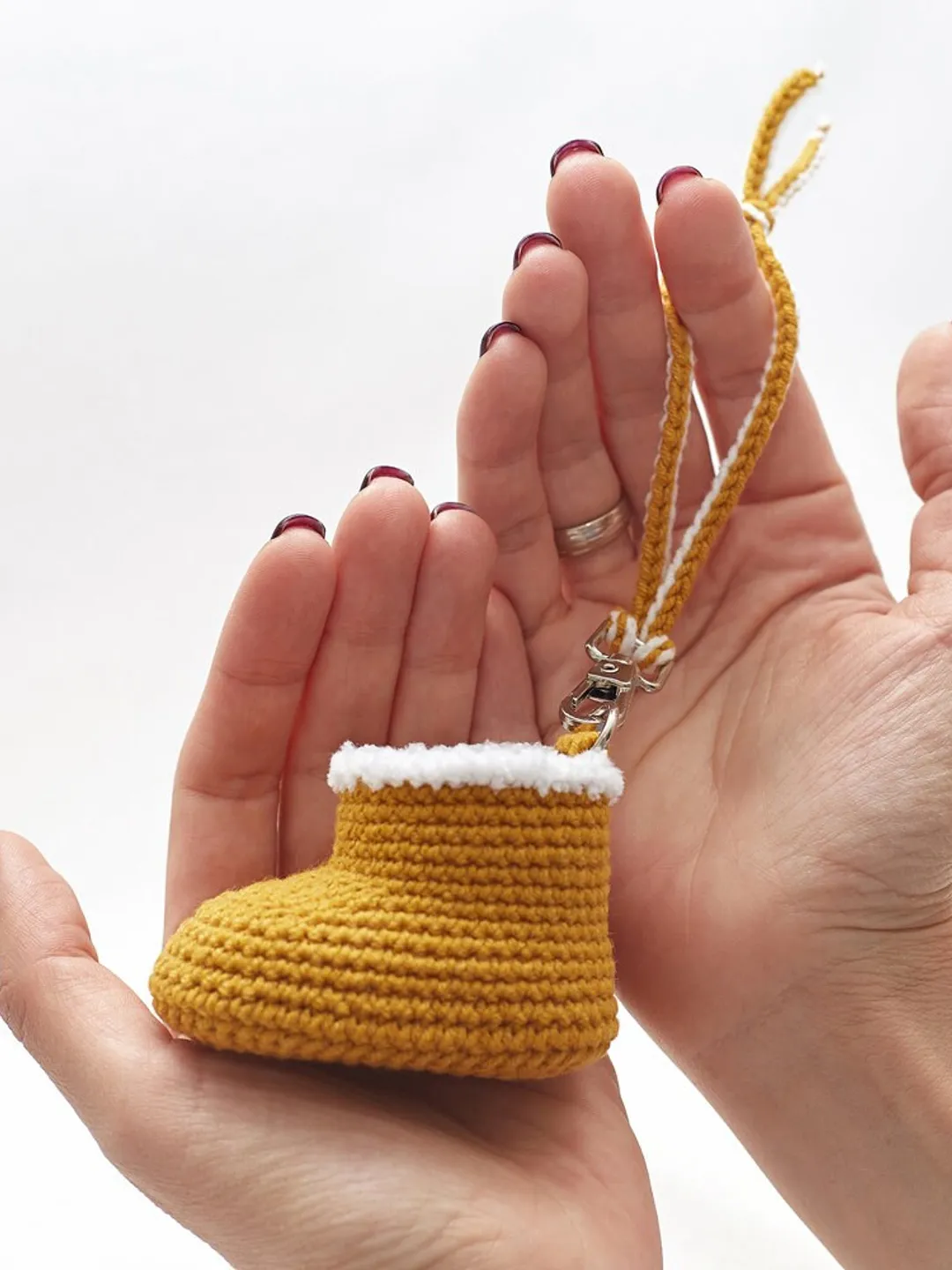 Stocking fillers for Christmas family gift. Merry holidays party favors present box idea with cute crochet yellow baby bootie Santa