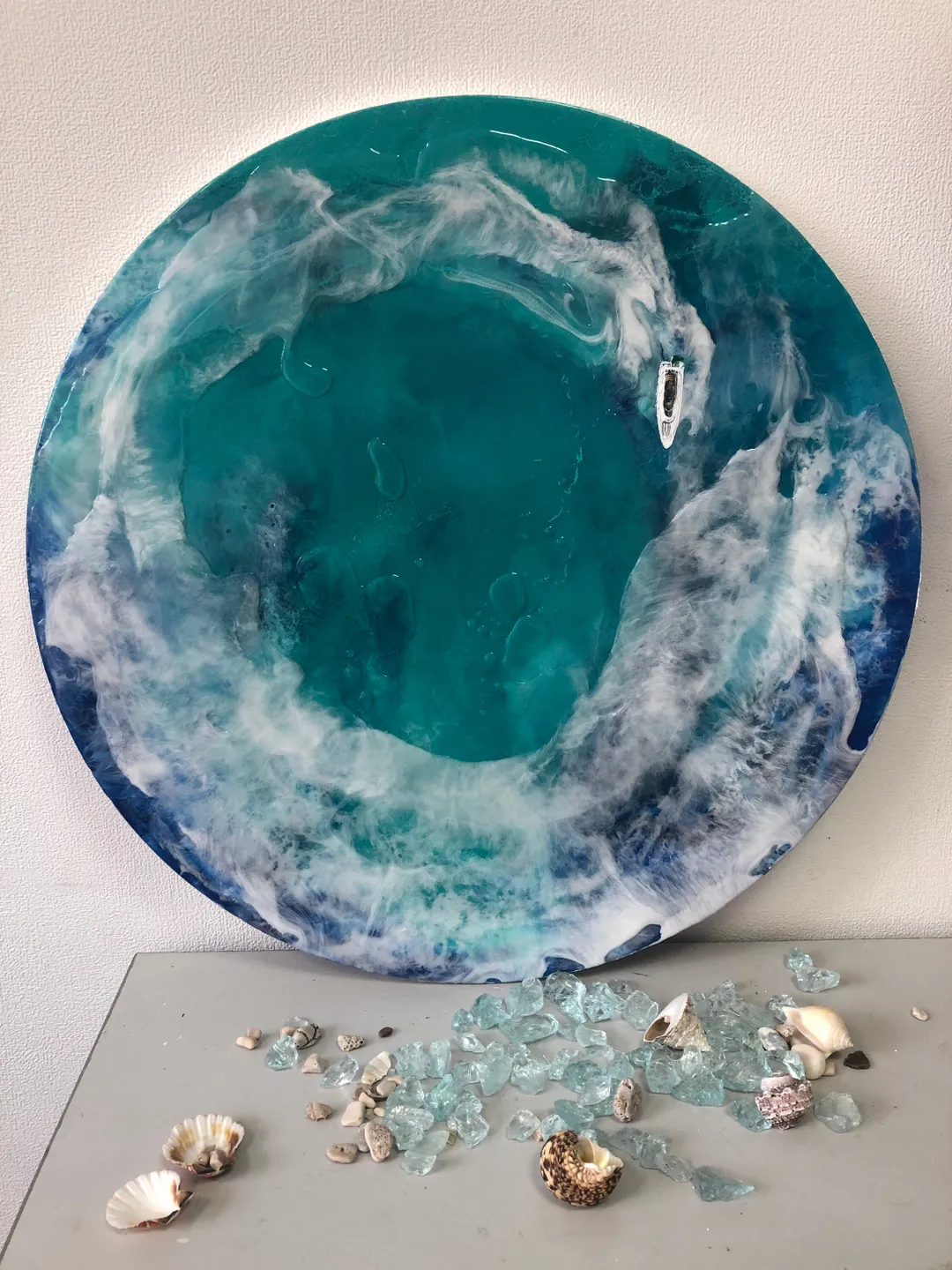Round epoxy resin painting for wall decoration in nautical theme with waves, yacht and ocean