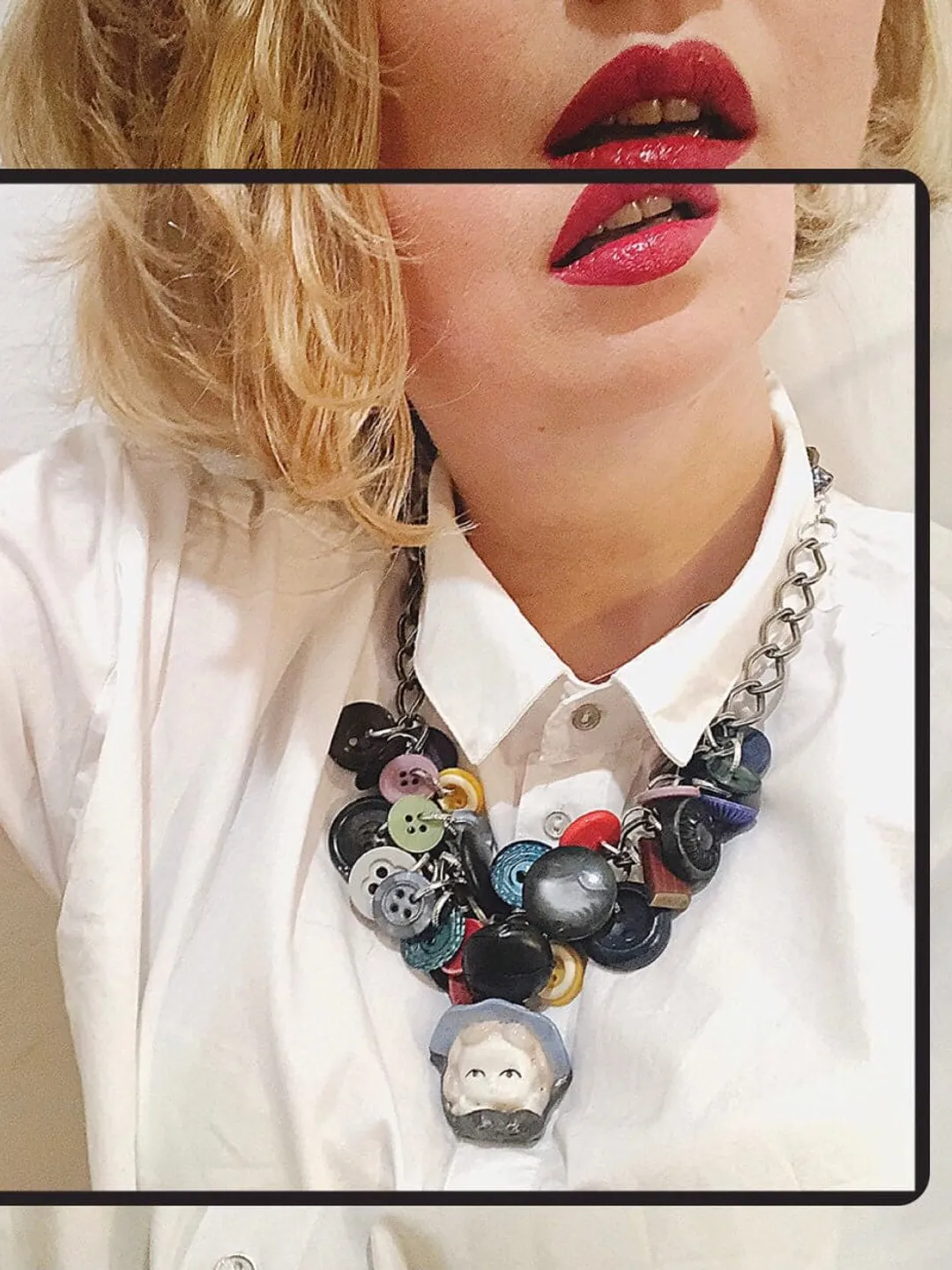 Necklace with a vintage porcelain doll and vintage buttons on a silver chain