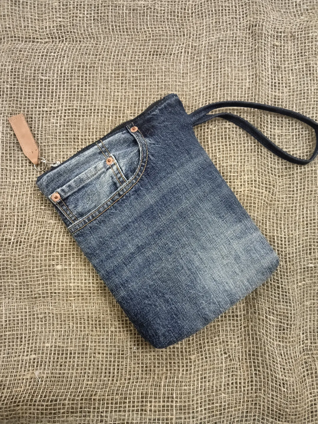 A small denim clutch bag , recycled jeans purse, closes with a zipper, 3 functional jeans pockets on the outside, cotton and 2 pockets on the inside.