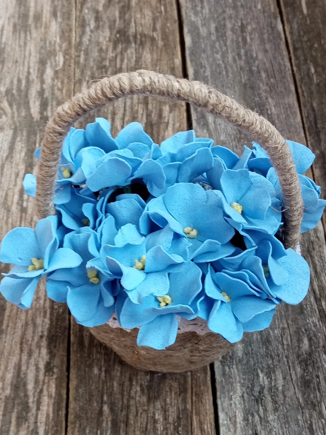 Delicate composition blue violets in linen basket. Everything from the flower stamens to the basket is made by hand.