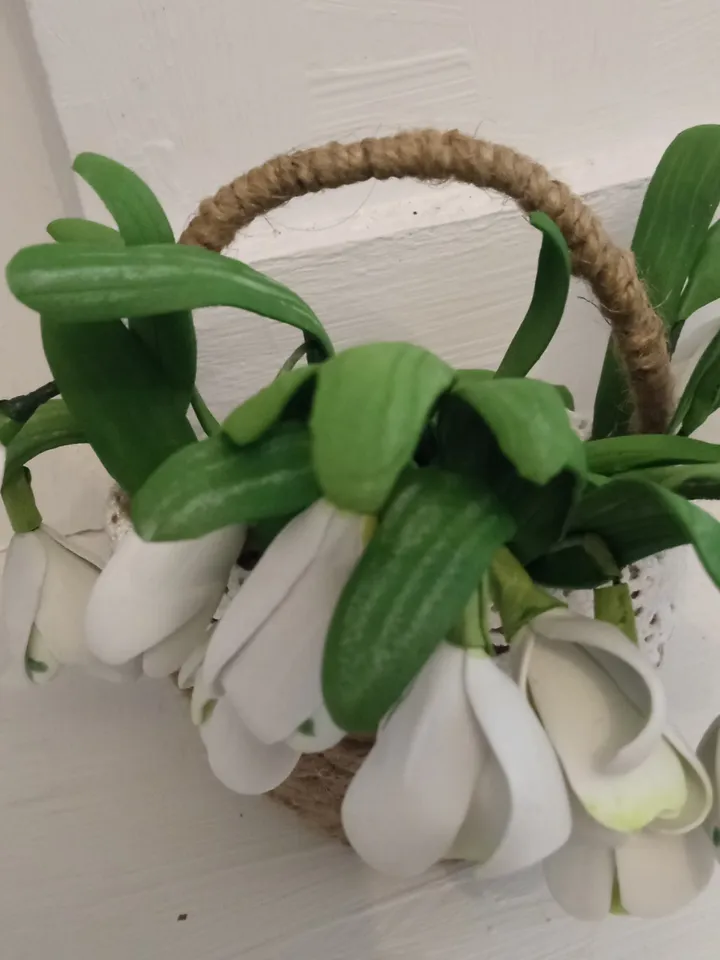 A bouquet of delicate handmade snowdrops in a basket