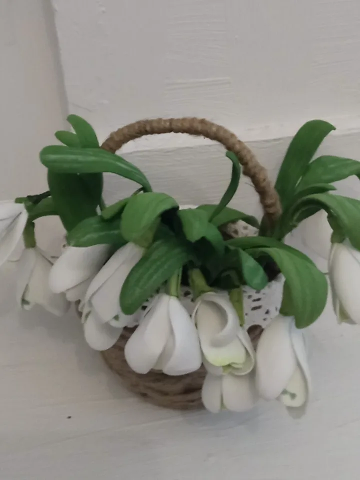 A bouquet of delicate handmade snowdrops in a basket