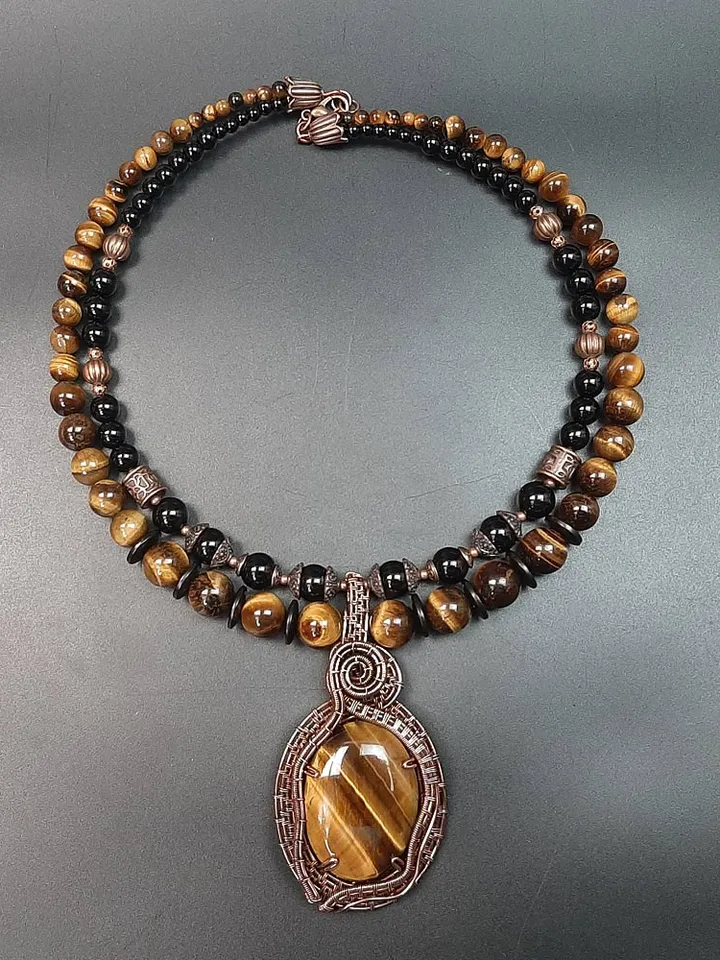 Handmade pendant made of Tiger Eye stone and copper wire.