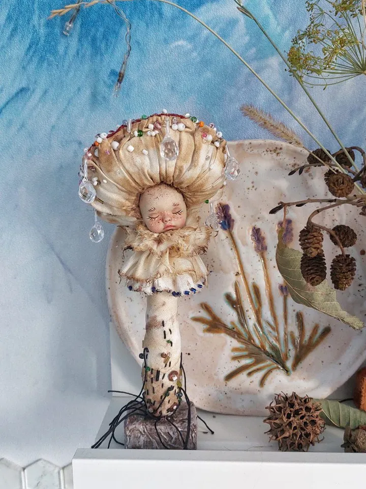 Art doll Mushroom. Unusual handmade figurine. Sleeping child-toy in the image of a fly mushroom. Unique statuette is made of fabric and polymer clay, decorated with beads and beads. An art object for your interior and collection