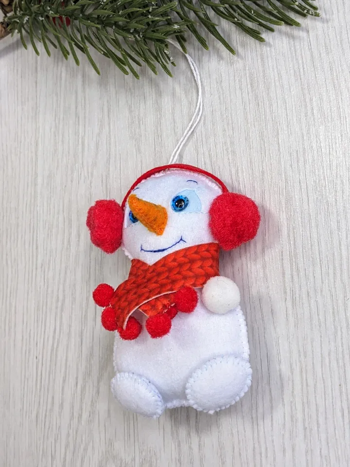 Cute felt snowman. Snowman with blue eyes and red scarf