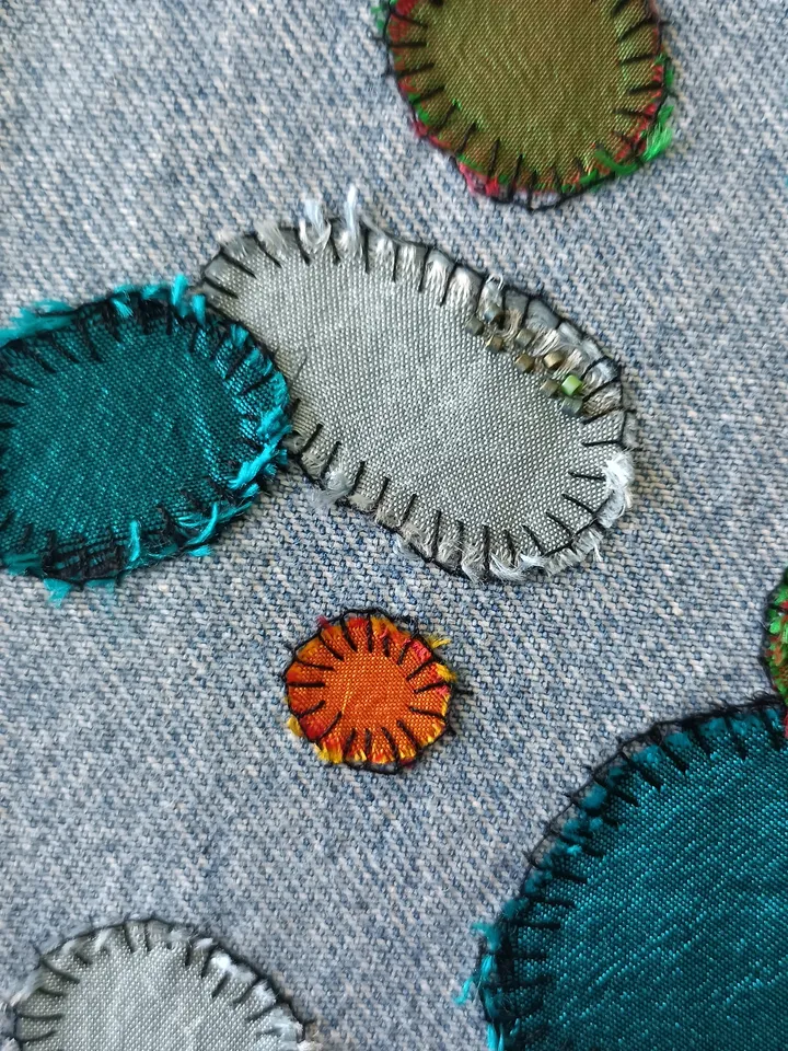 Upcycled denim/silk boro patch – visible mending.