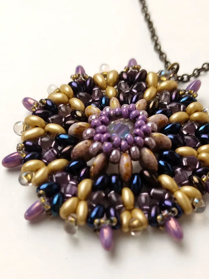 Round lilac-gold openwork beaded pendant with a faceted bead on a chain