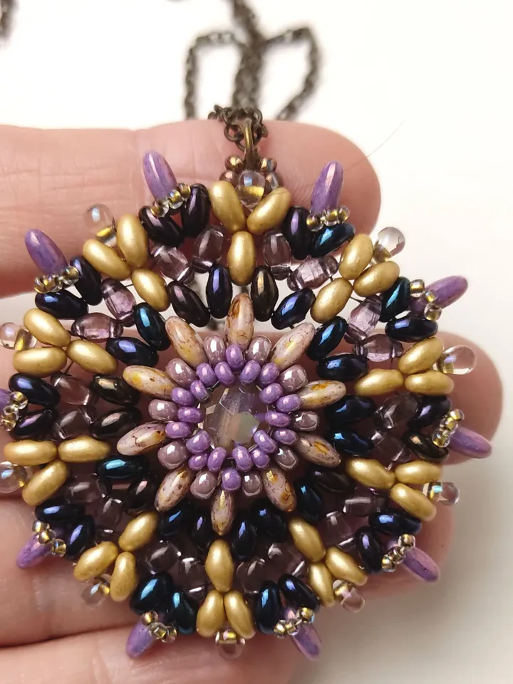 Round lilac-gold openwork beaded pendant with a faceted bead on a chain
