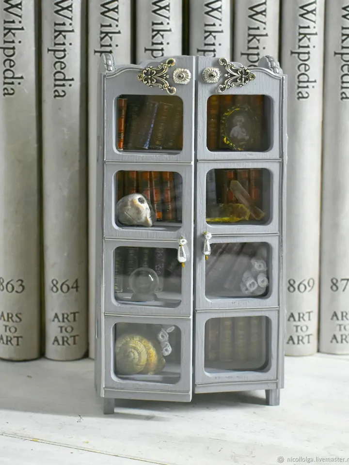 A miniature bookcase with books on a bookshelf between books
