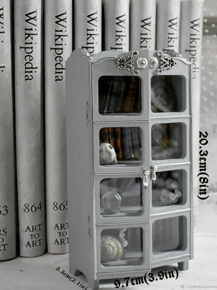 A miniature bookcase with books on a bookshelf between books