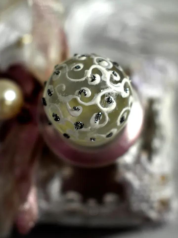 Rose glass bottle for storing perfumes and aroma oils with a voluminous decor