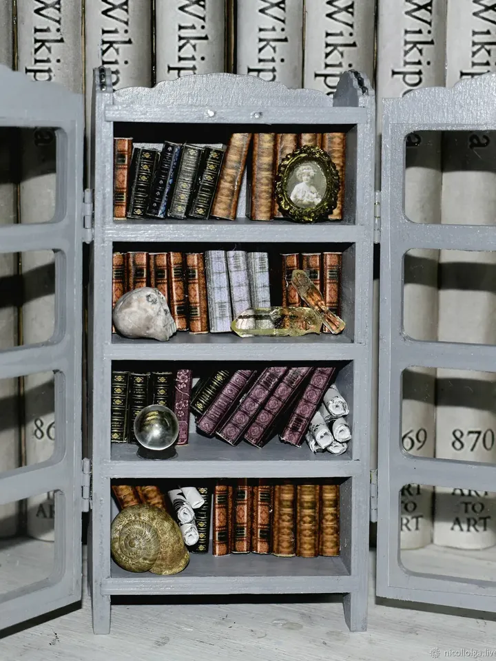A miniature bookcase with books on a bookshelf between books