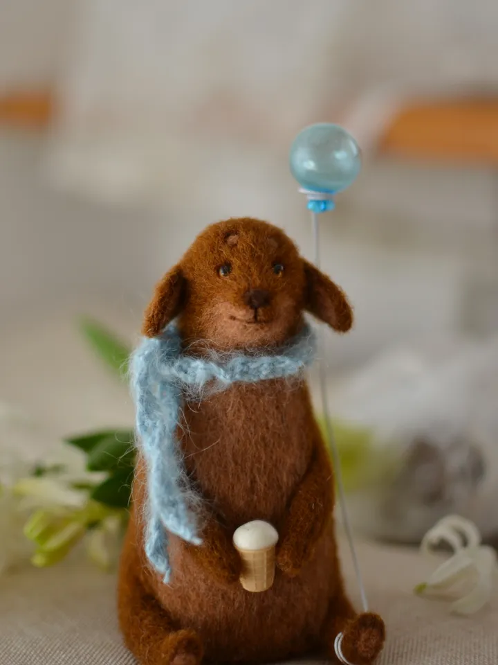 Handmade toy. Dachshund puppy in a scarf, with ice cream and a ball