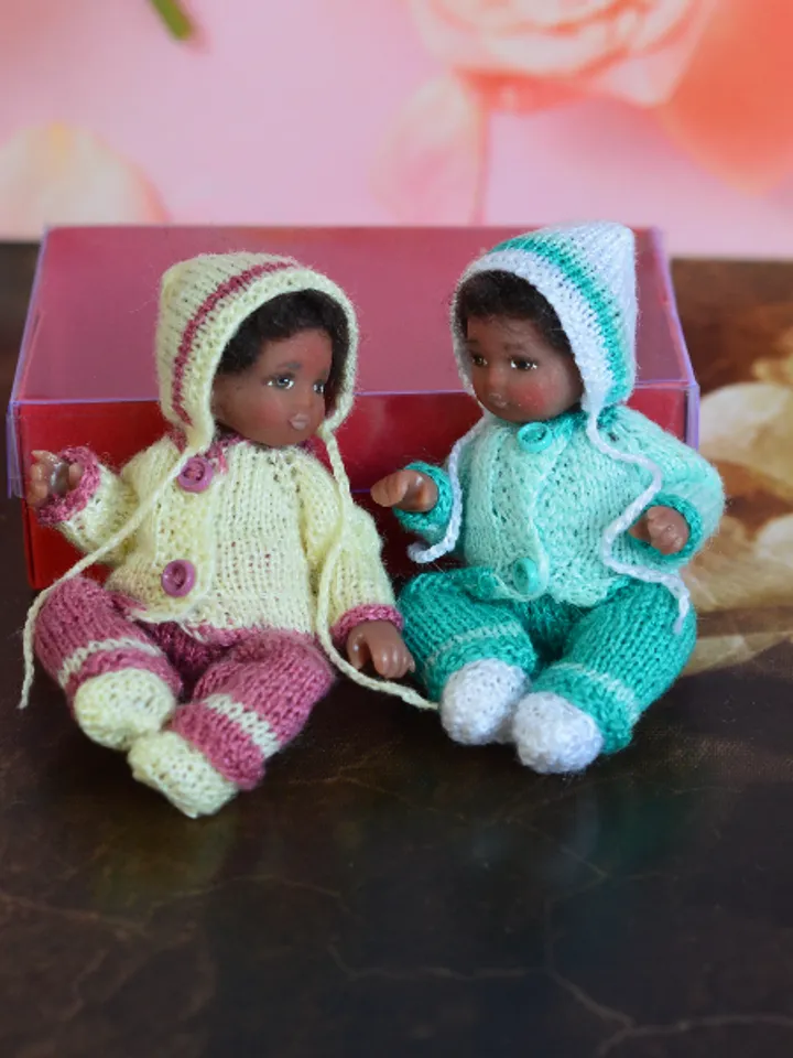 Miniature doll child in 12th scales. A baby for the dollhouse. Baby in a knitted suit.