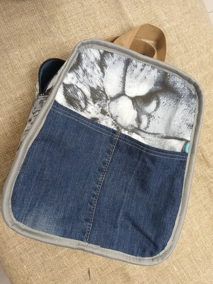 Casual unisex denim backpack made from eco-frendly recycled jeans, with 6 pockets outside and 2 pockets inside (1 with a zipper), strong belt on adjustable straps. Inside is colored cotton fabric. The back wall is quilted.