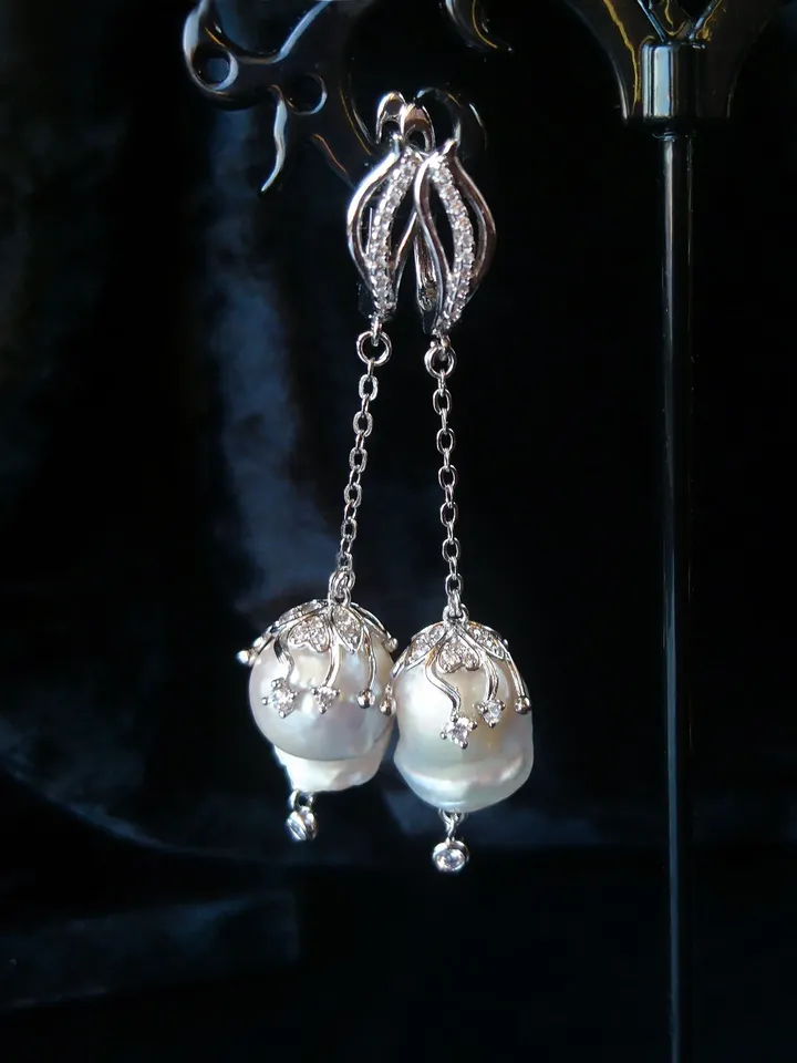Earrings with baroque pearls and circus pendants on chains