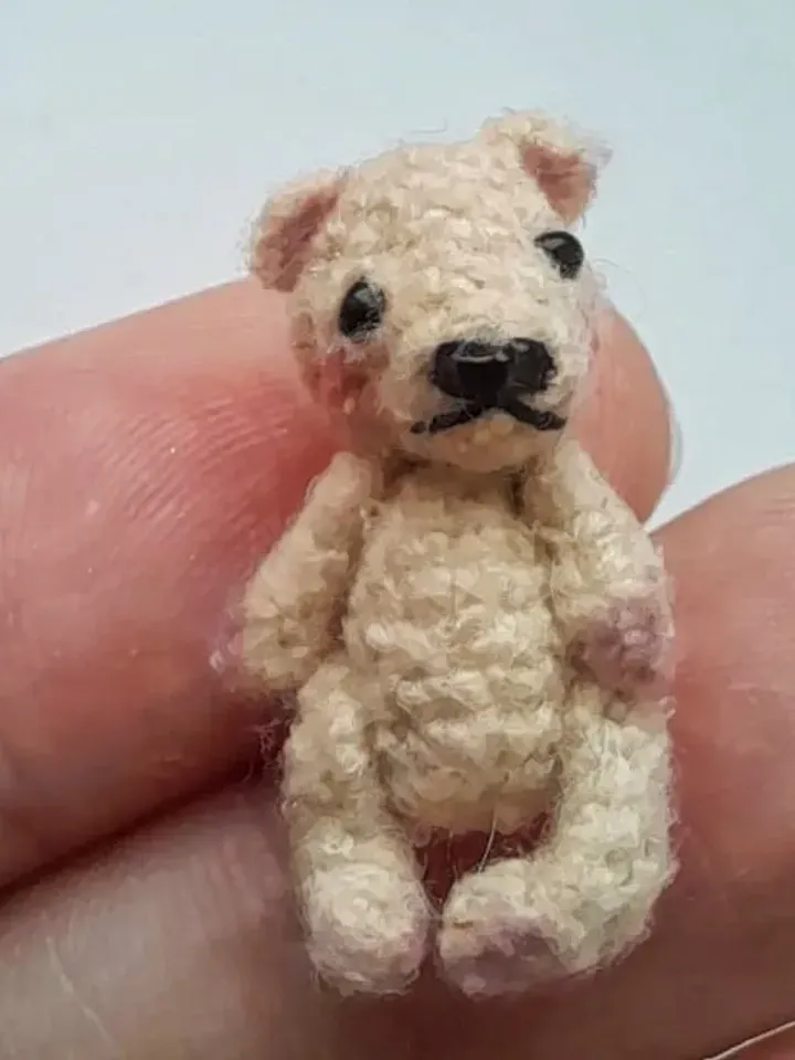 Miniature crochet bear in a mushroom house