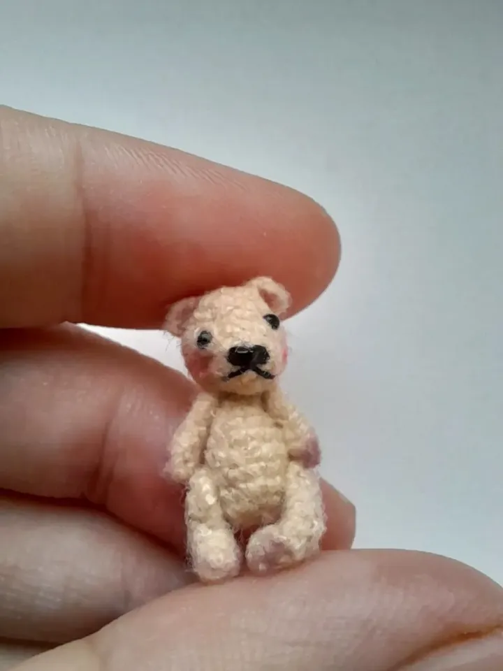 Miniature crochet bear in a mushroom house