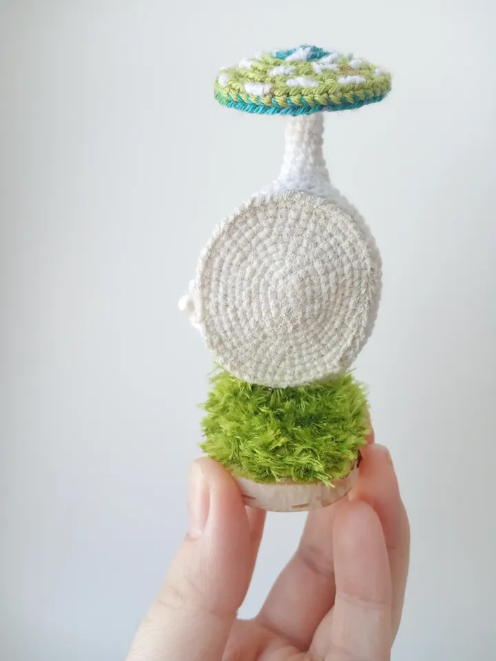 Miniature crochet bear in a mushroom house