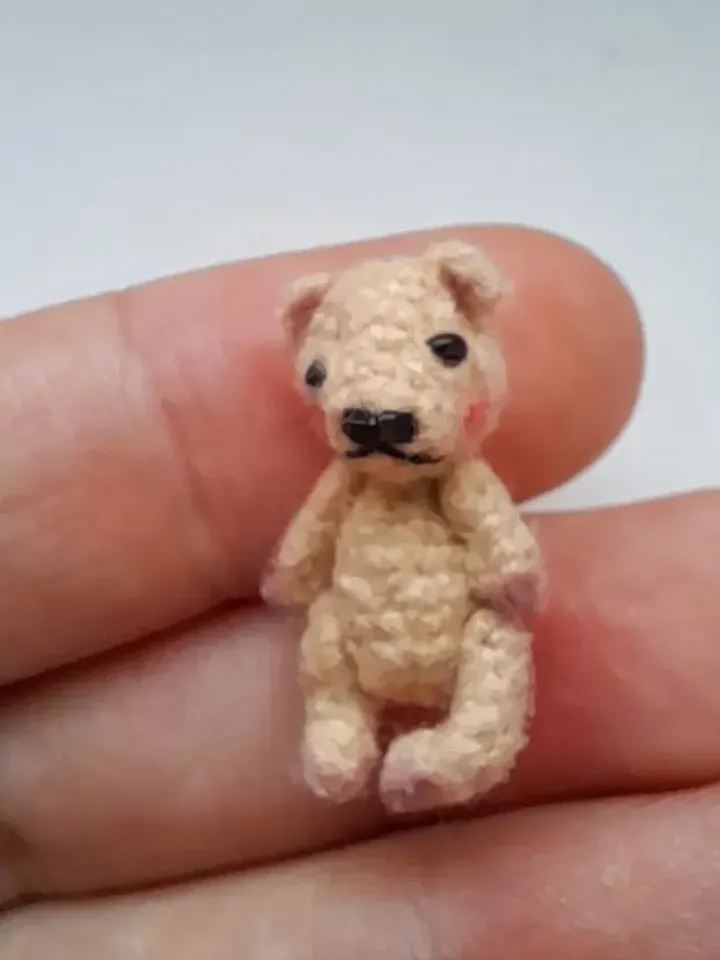Miniature crochet bear in a mushroom house