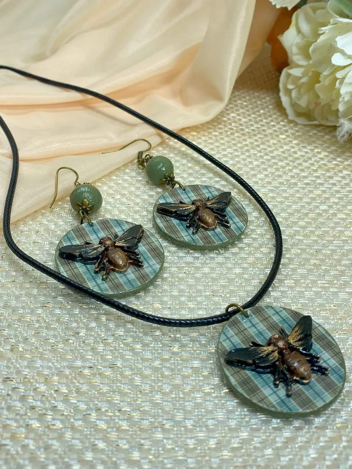Author's set of handmade jewelry.Earrings and pendant on a cord with voluminous flies.