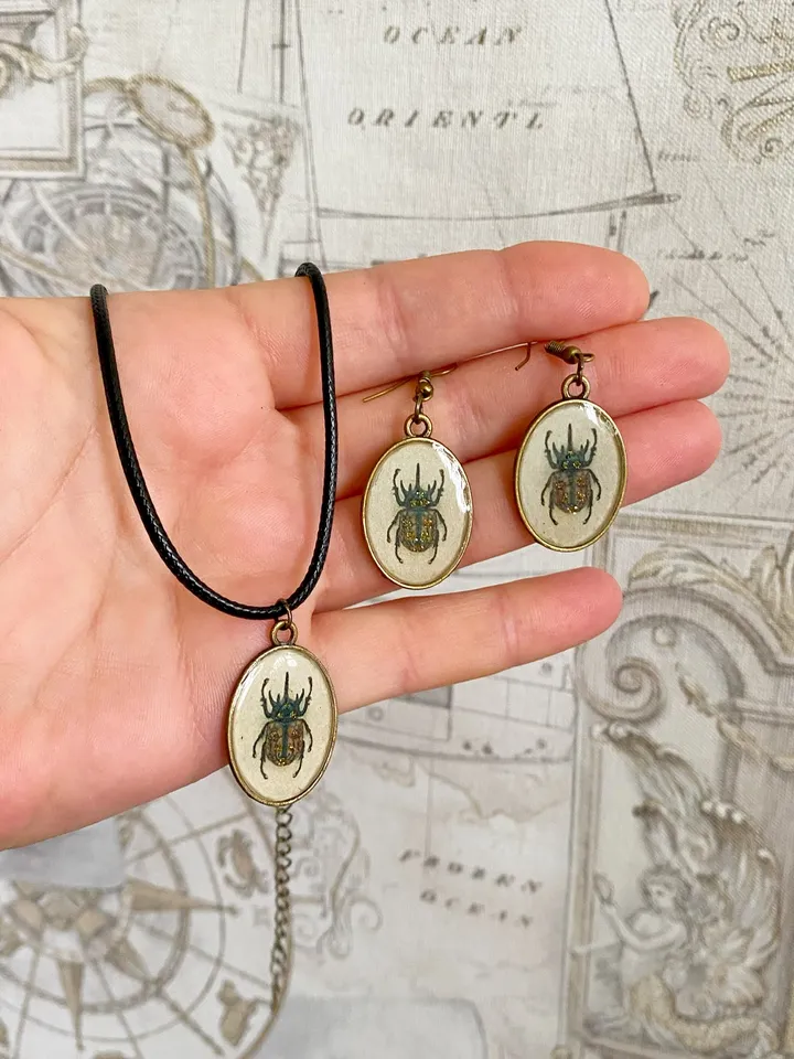 A set of jewelry with the image of beetles. Individual design.