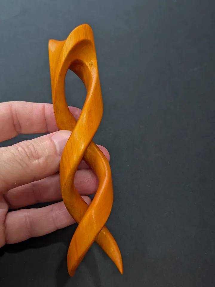 Spiral clip made of stabilized hornbeam orange. Twisted wooden hair fork.