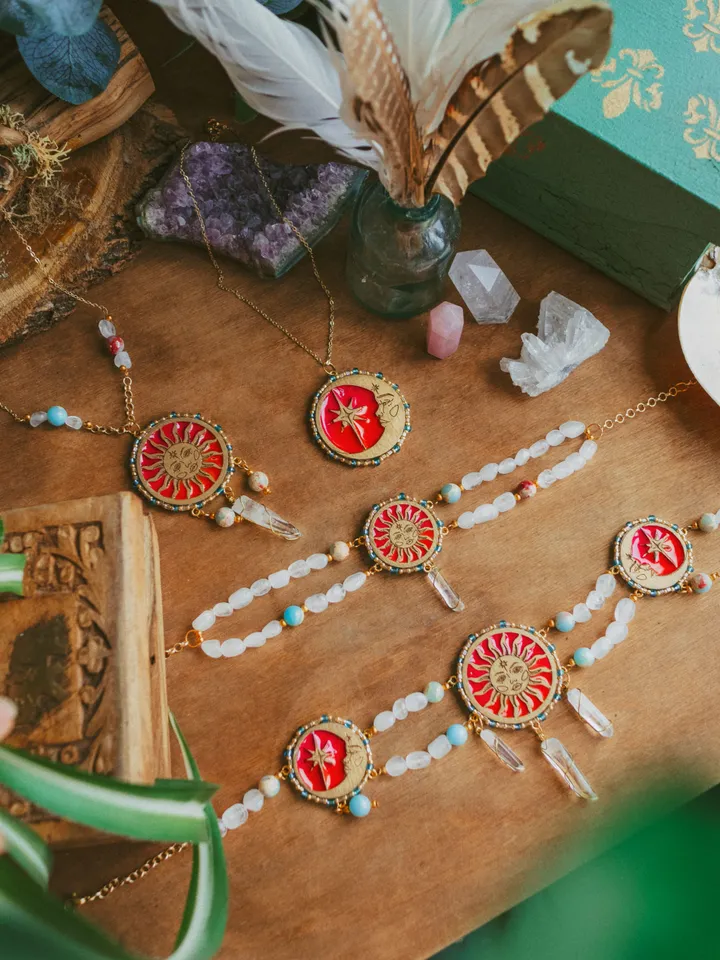 Pendant necklace When The Sun Meets The Moon with blue jasper and clear quartz crystals. Gold jewelry with celestial design in sunset red and orange color with beading. Maylina Soul