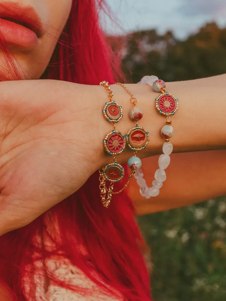 Charm bracelet When The Sun Meets The Moon with blue jasper. Gold stackable jewelry ith celestial design in sunset red and orange color with beading. Adjustable length. Maylina Soul