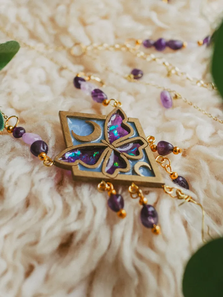 Pendant necklace Moonlight Serenity with amethyst and clear quartz crystals. Gold jewelry with butterflies and moons in light blue and deep purple color and iridescent shine. Maylina Soul