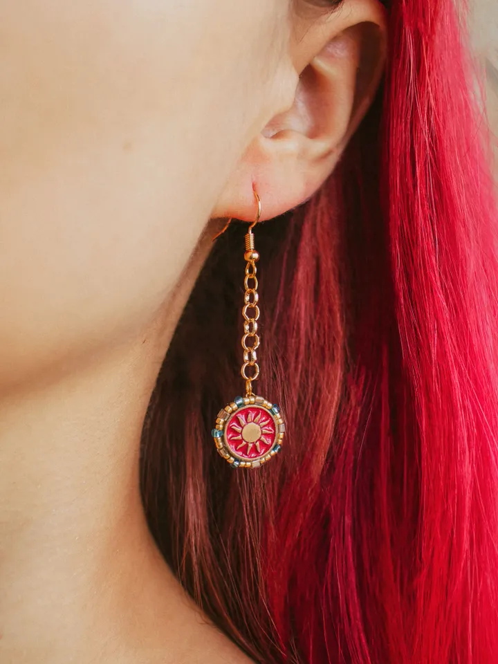 Asymmetrical small earrings When The Sun Meets The Moon with chains. Gold jewelry with celestial design in sunset red and orange color with beading. Maylina Soul