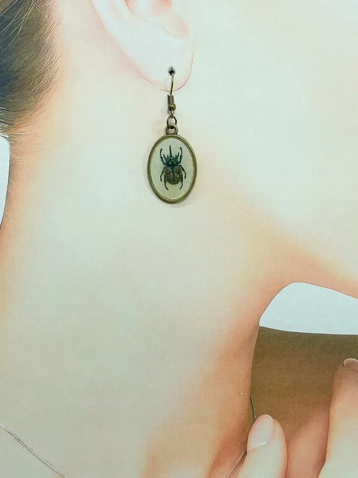 A set of jewelry with the image of beetles. Individual design.