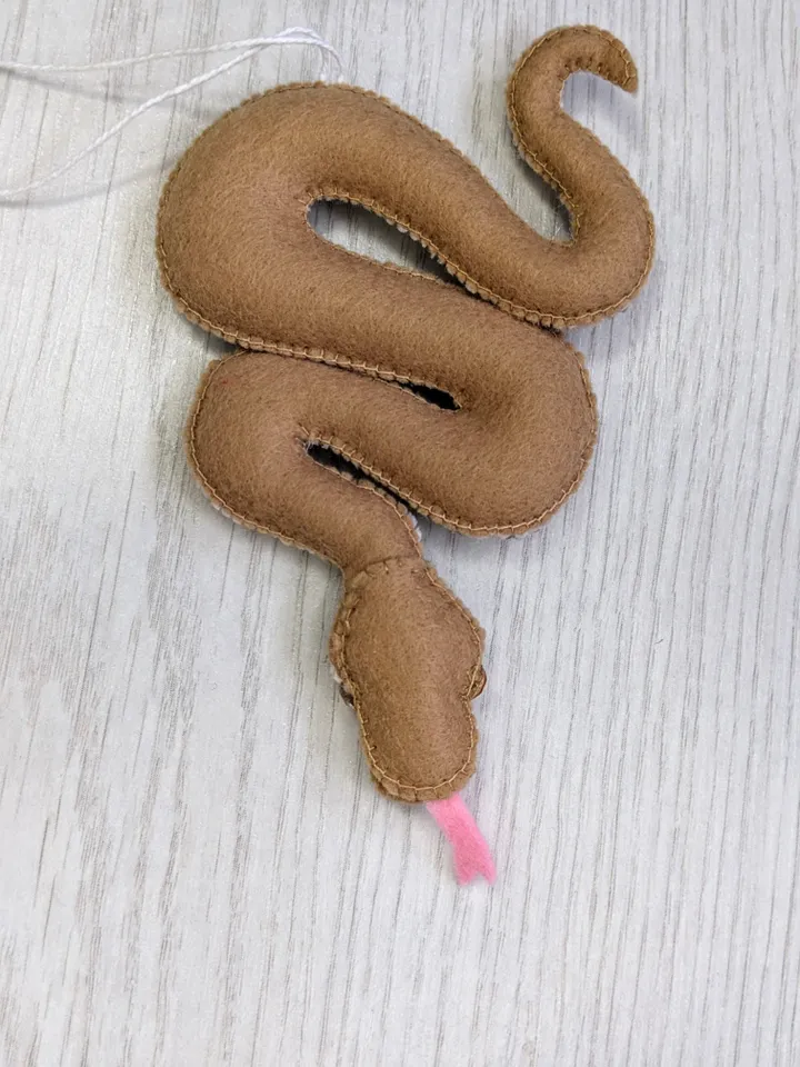 A reticulated brown snake is a symbol of the new year 2025 according to the eastern calendar. Christmas gift felt snake.